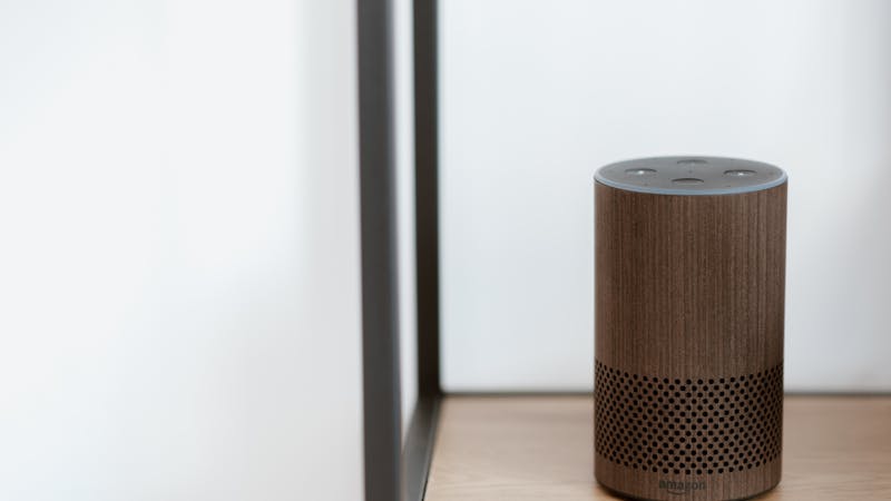Trois enceintes connectées intelligentes disposées sur un meuble de salon moderne.