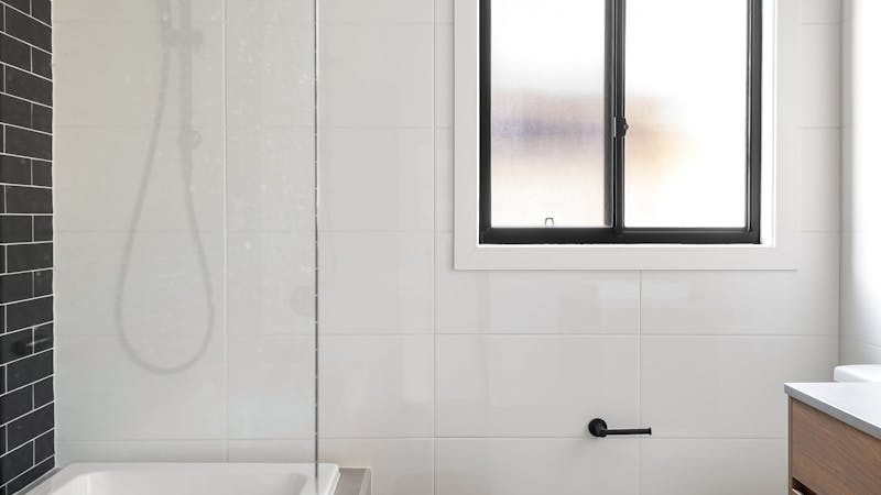 Pose de carreaux de céramique sur le sol d'une salle de bain moderne.