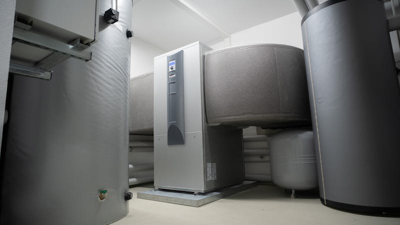 Chauffe-eau à thermopompe moderne installé dans une salle mécanique résidentielle.