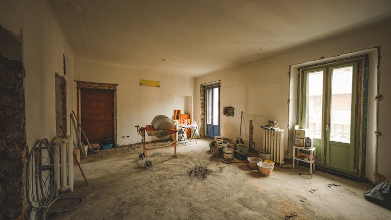 Entrepreneur en construction et propriétaire discutant de plans de rénovation résidentielle
