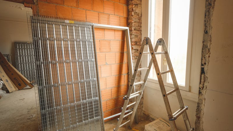 Personne mesurant un plancher avec un ruban à mesurer et calepin