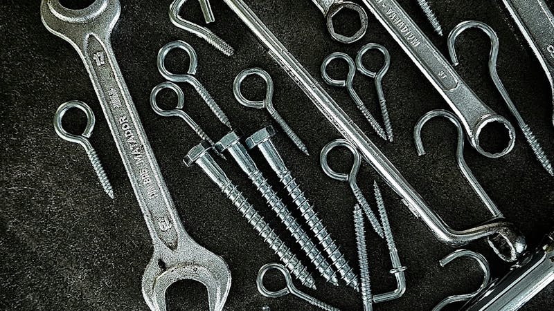 Une sélection d'outils manuels essentiels disposés sur un établi en bois.