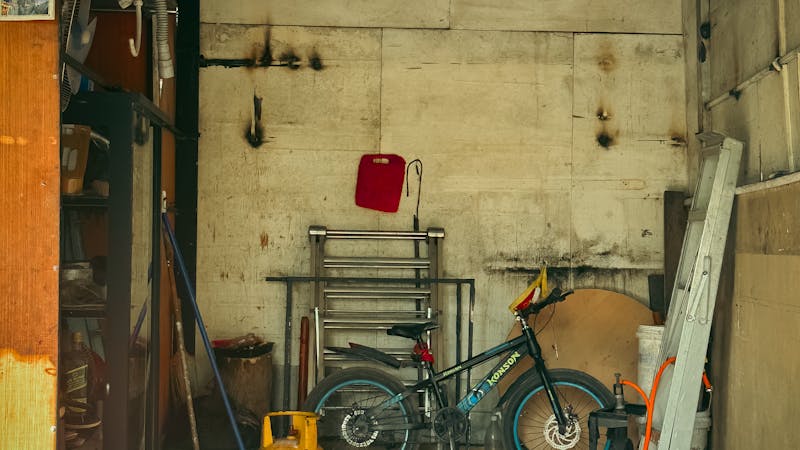 Garage organisé avec panneaux perforés, étagères et armoires de rangement modernes.