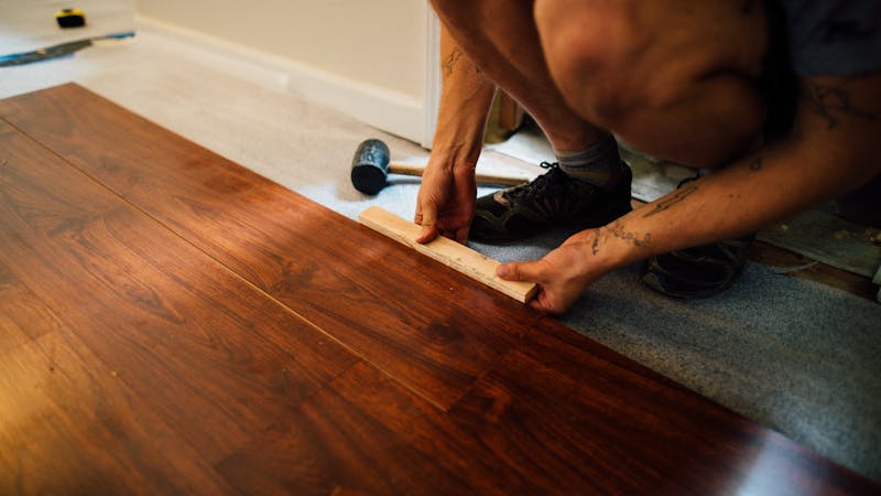 Ponçage professionnel d'un plancher de bois franc ancien en rénovation.