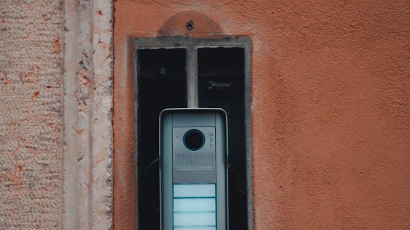 Sonnette vidéo intelligente installée sur le cadre d'une porte d'entrée moderne